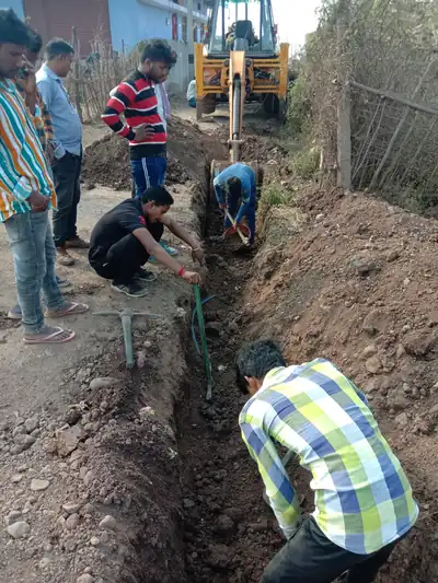 GVR crew working in a pipeline trench next to a JCB