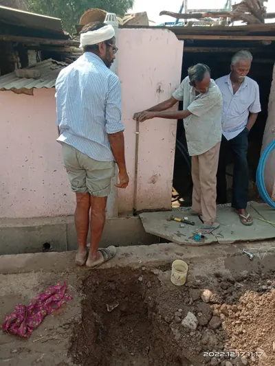 Team fitting a tap connection at a house