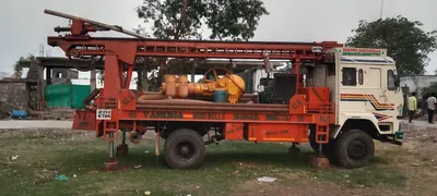 Truck-mounted drilling rig AP 29 B 6786 with its compressor, parked on grass